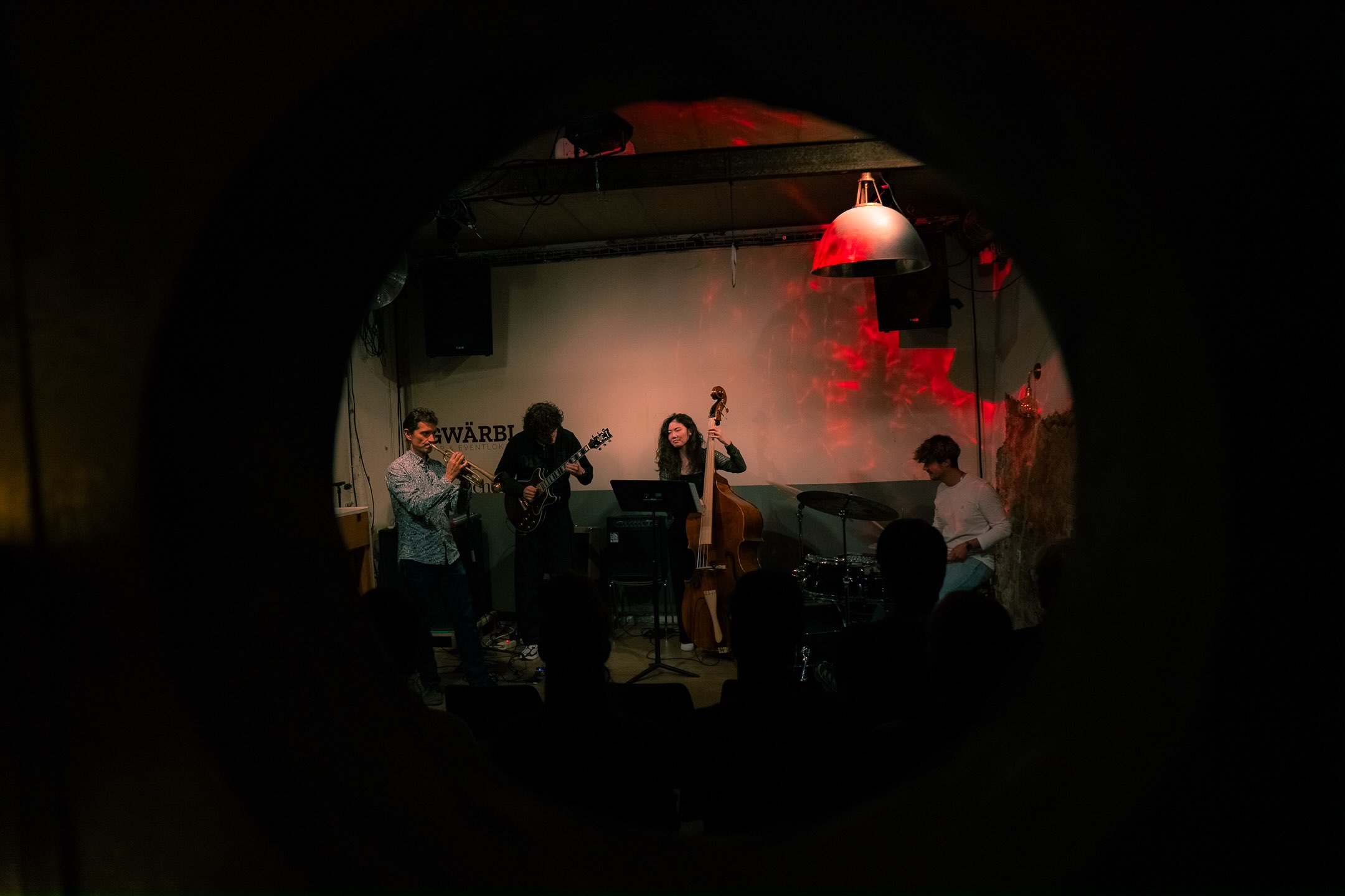 Xiao playing double bass with a trumpet player, guitarist and drummer at Thursday Night Jam